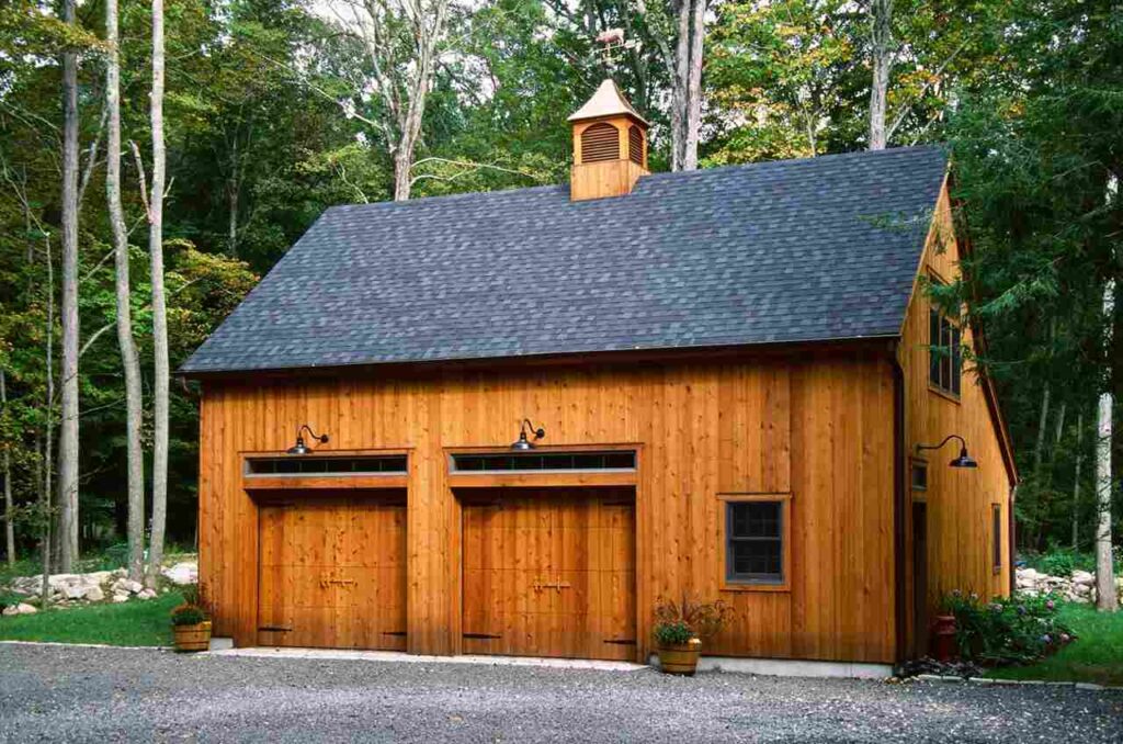 A black roof on cedar garage house with black lights above the door