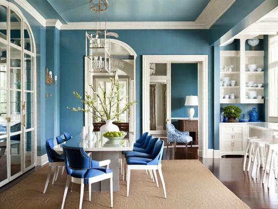 A blue living room with glass white table and chairs