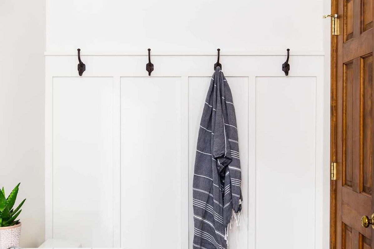 A board and batten bathroom with hooks and wooden door