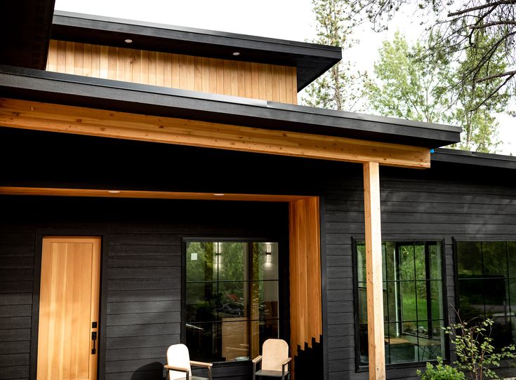 A black house with cedar panels and glass windows