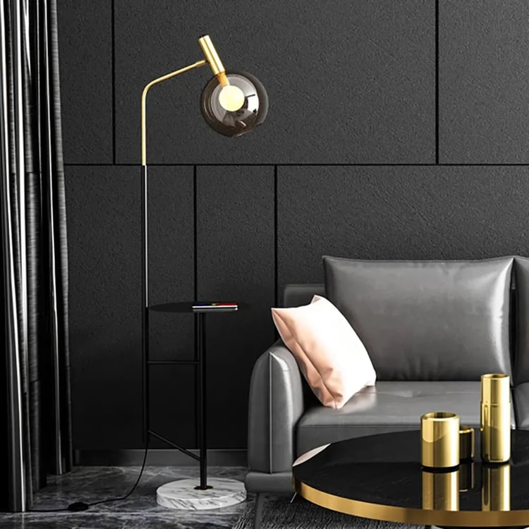 A black living room with floor lamp with grey sofa and golden table