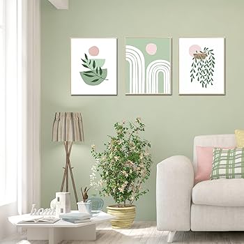 White frames on sage green wall and lamp on the corner