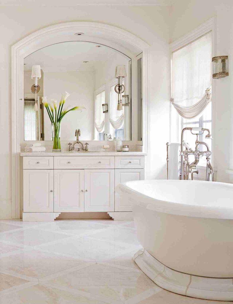 A white bathroom and slivers fitting and mirror nad white bathtub