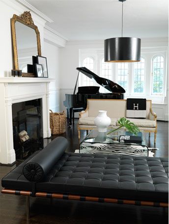 A white living room with black piano and sofa