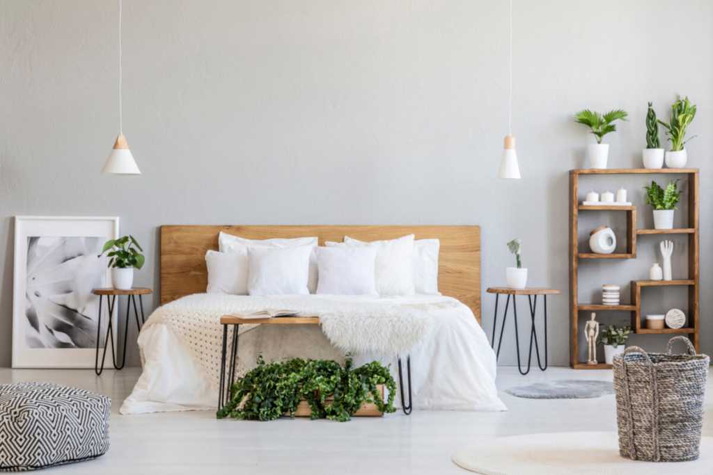 A grey bedroom white potted plants wooden bedding bed 