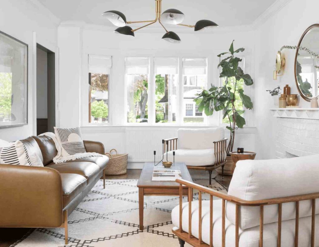 A white living room with grey light fixture and windows with curtains