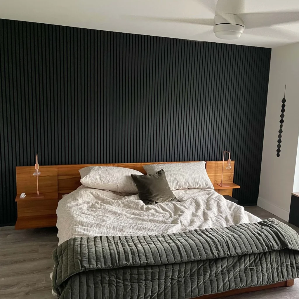 A black accent wall and grey bedroom 