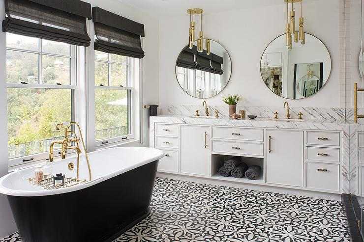 A white. bathroom with black bathtub and mirror on the wall 
