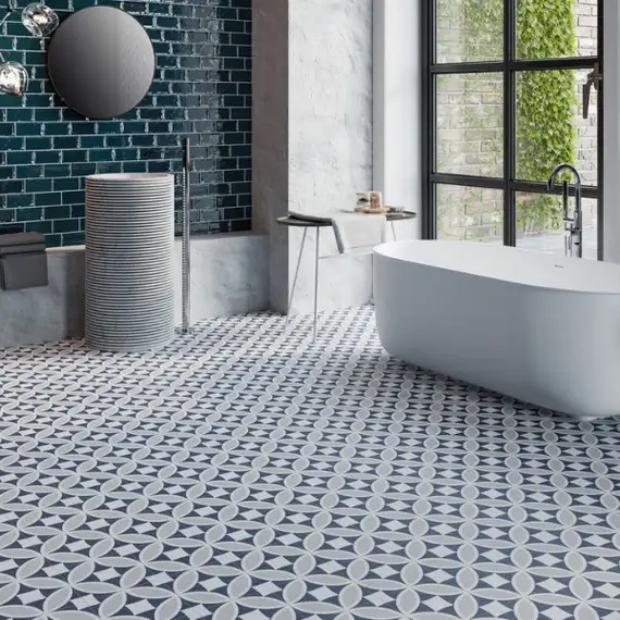 A blue and grey floor tiles with geometric pattern and bathtub with windows 