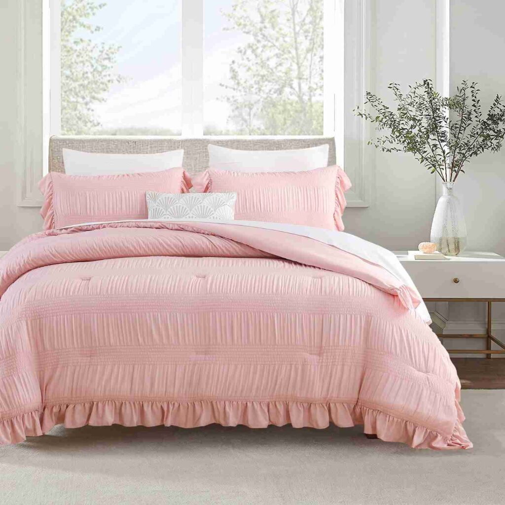 A white bedroom with pink blanket with pillow and white pillow 