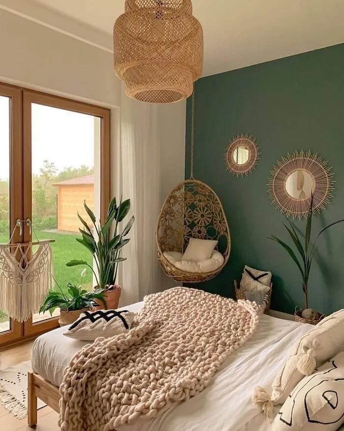 A green and grey bedroom with boho style throw on the bed 