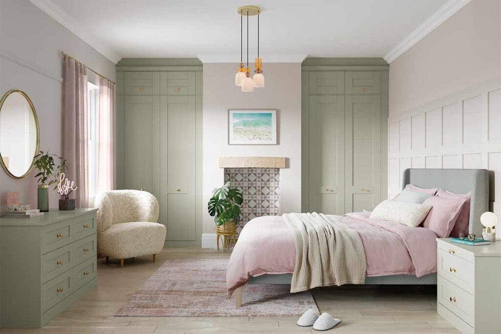 A sage green bedroom with cream and chair in the corner 