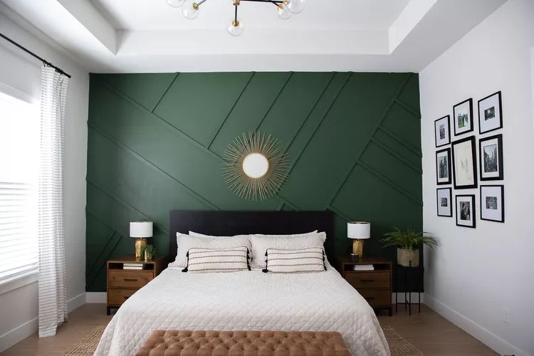 A grey and green bedroom with mirror on the wall 