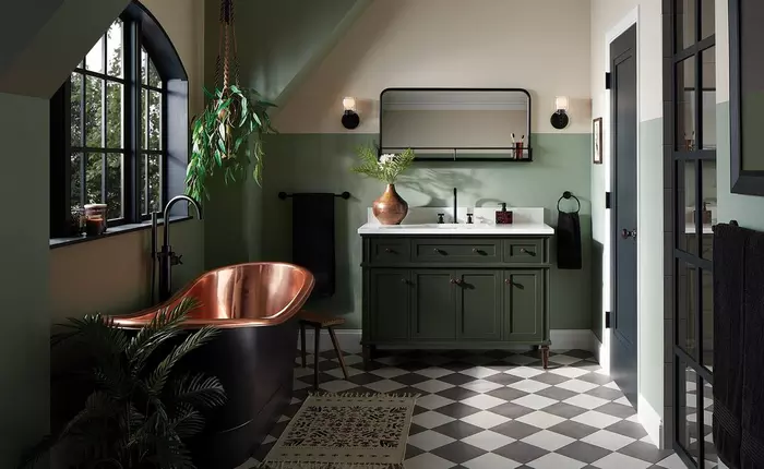 A bathroom with green vanity with black fixture and glass window 