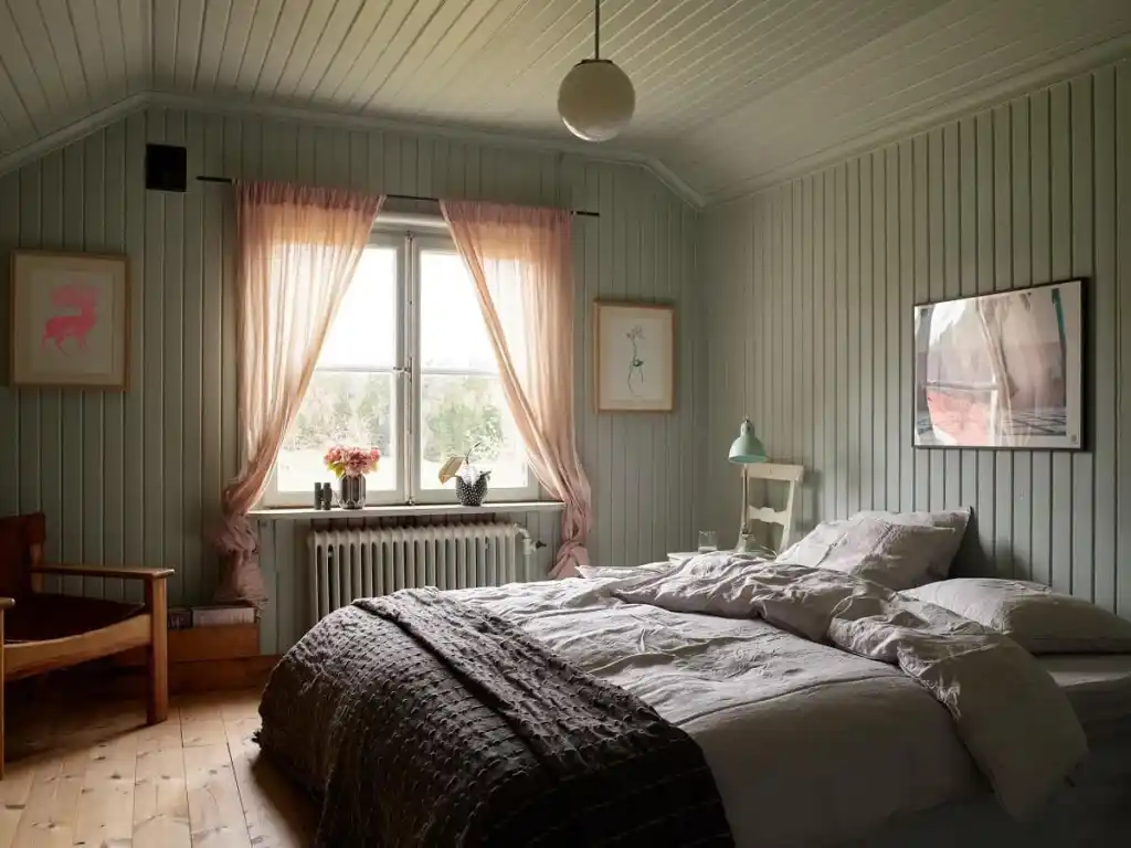 A green bedroom with windows and curtain and shiplap wall 