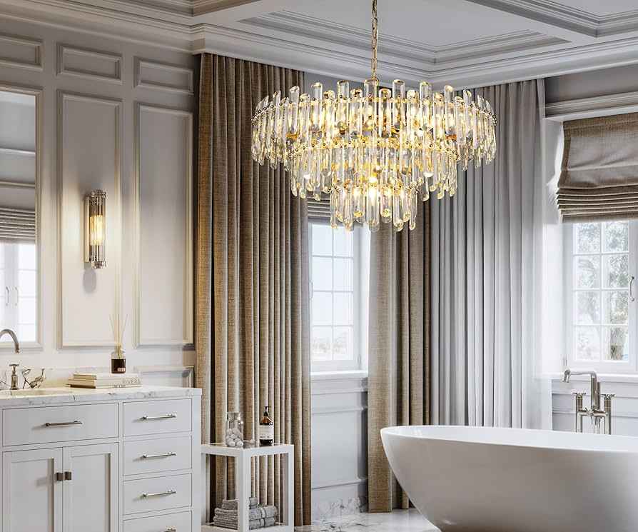A white bathroom with gold chandelier and white vanity and window 
