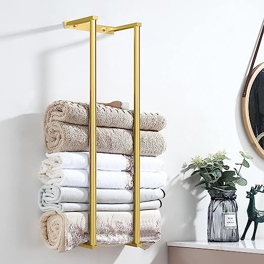 A white bathroom with gold towel rack 