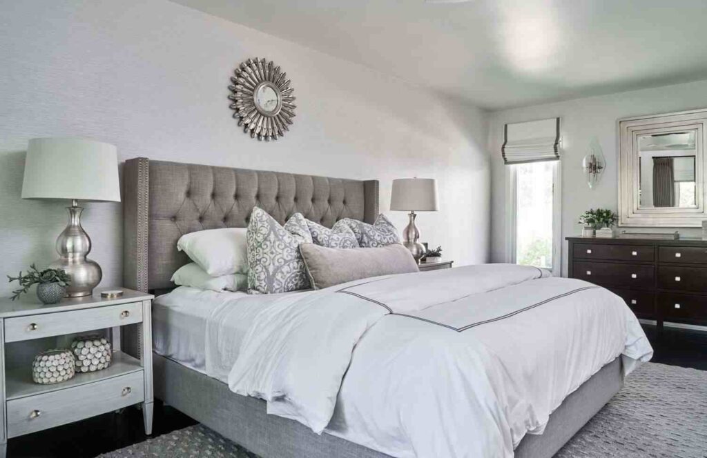 A white bedroom with Grey headboard and nightstand and vanity 