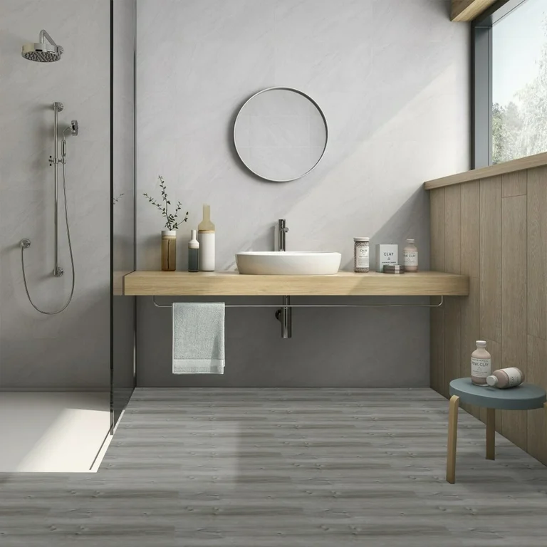 A vinyl peel and stick floor tile and glass shower door and wooden slaps with white sink 
