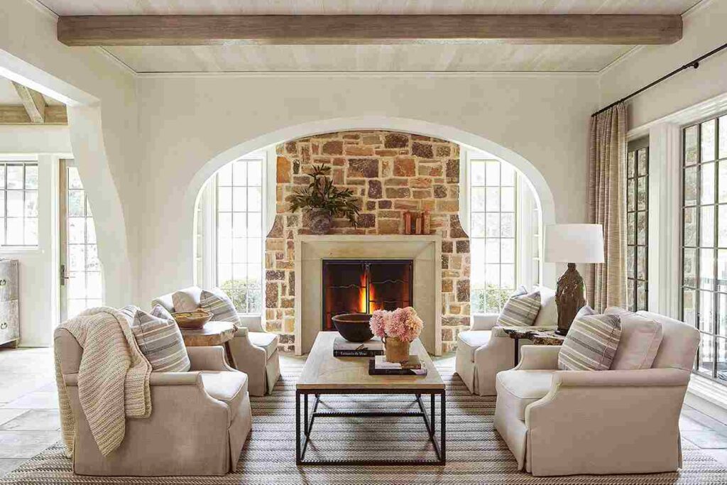 A white living room with grey sofa and stone fire place in living room