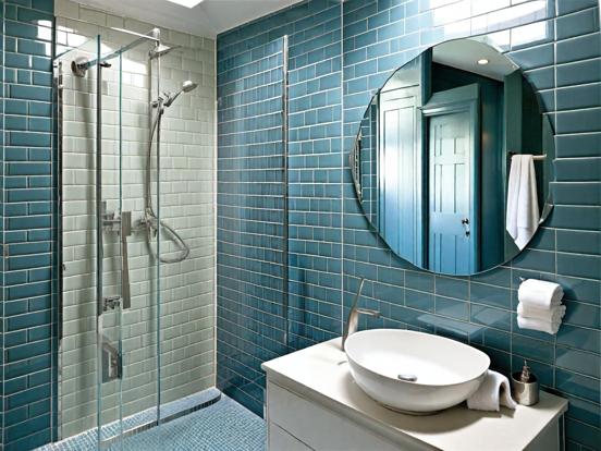 A light blue grey wall and sliver kit and mirror on the wall 