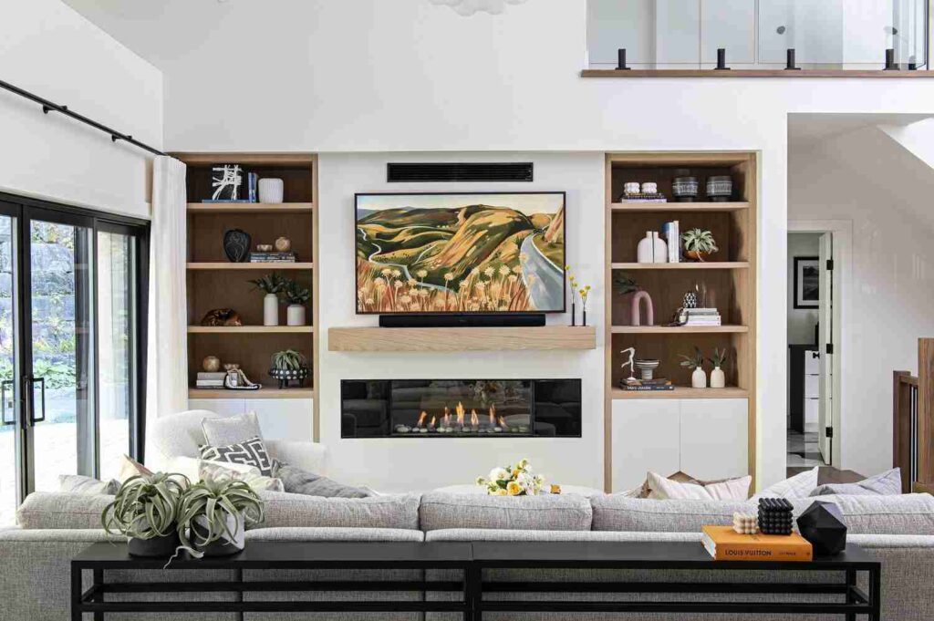 A built shelves and tv on the wall and fireplace 