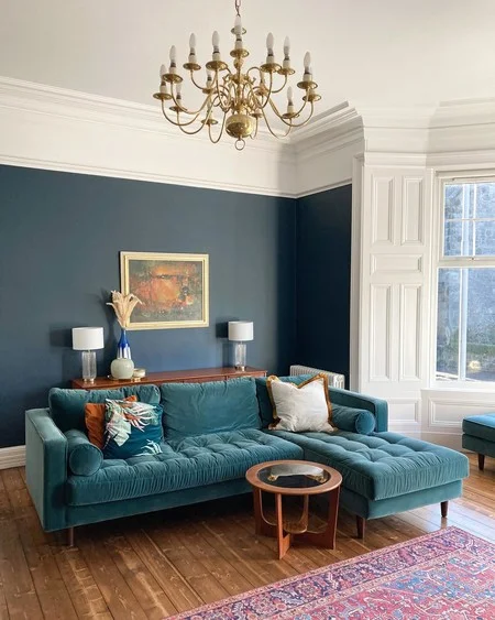 Traditional chandelier in blue living room and white lamp painting on the wall 