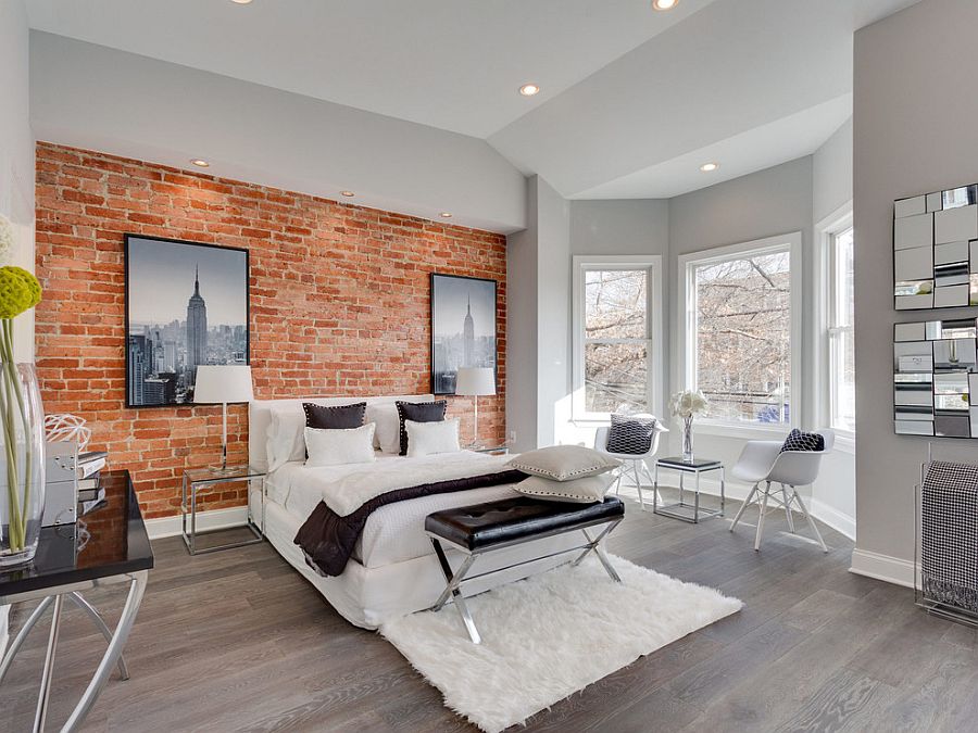 A grey bedroom with brick wall and wooden floor and windows in the bedroom 