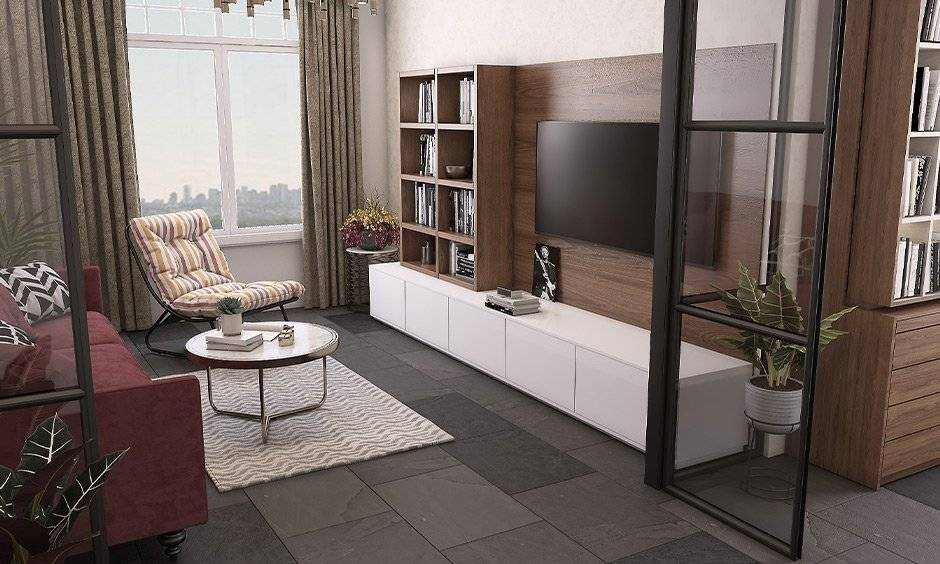 A living room with tv on wooden wall with windows and curtain 