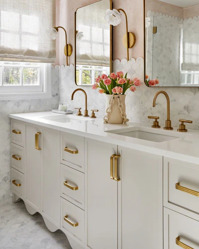 A white vanity with vintage gold knob and mirror on the wall 