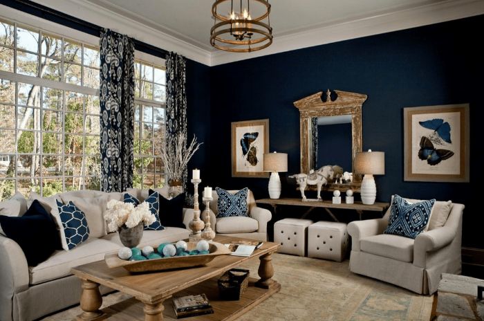 A living room with curtains and windows and frames on the wall and grey sofa with cushion 