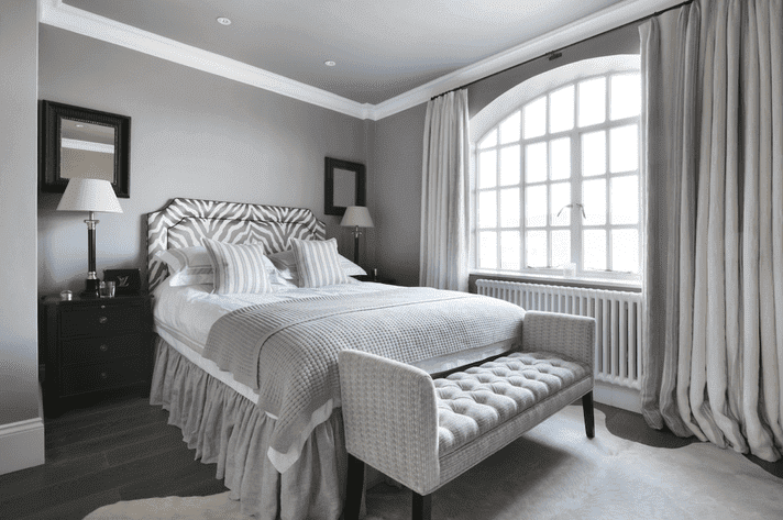 A white trim windows on grey bedroom and black framed on the wall 
