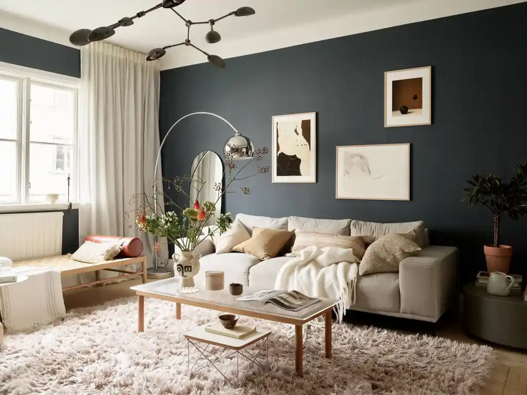 A blue living room with white windows with curtain and frame on the wall 