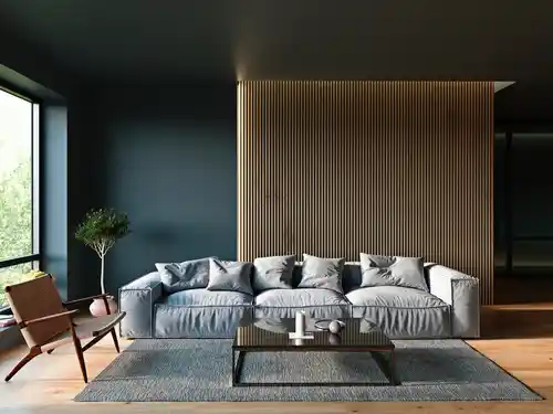 A wooden paneling in blue living room with grey sofa with cushion 