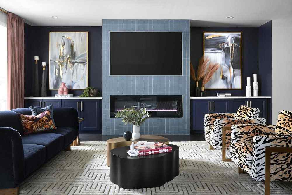A blue living room with tv wall and ornate painting on the wall and sofa and table 