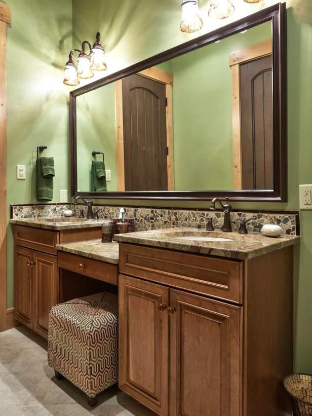 A light green bathroom with dual vanity and mirror on the wall