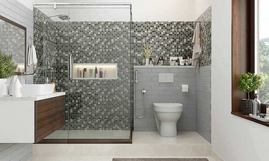 A sage green and grey  bathroom with glass shower door 