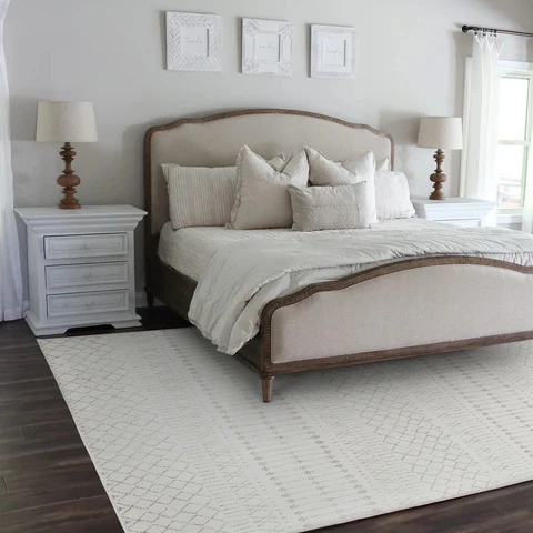 A grey bedroom with white rug on floor and nightstand 
