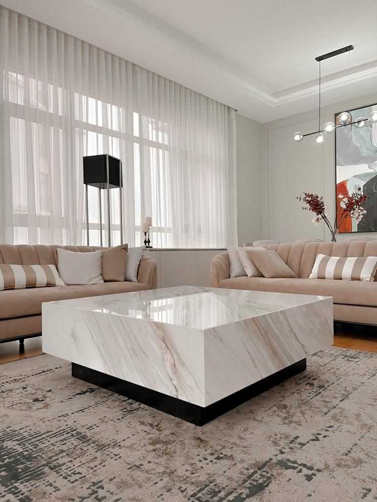 grey living room with white marble table and lights above the wall