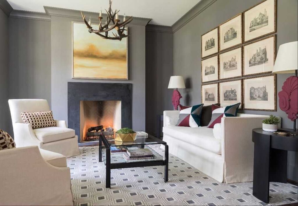 A grey living room with white sofa and metallic table n frames on the wall