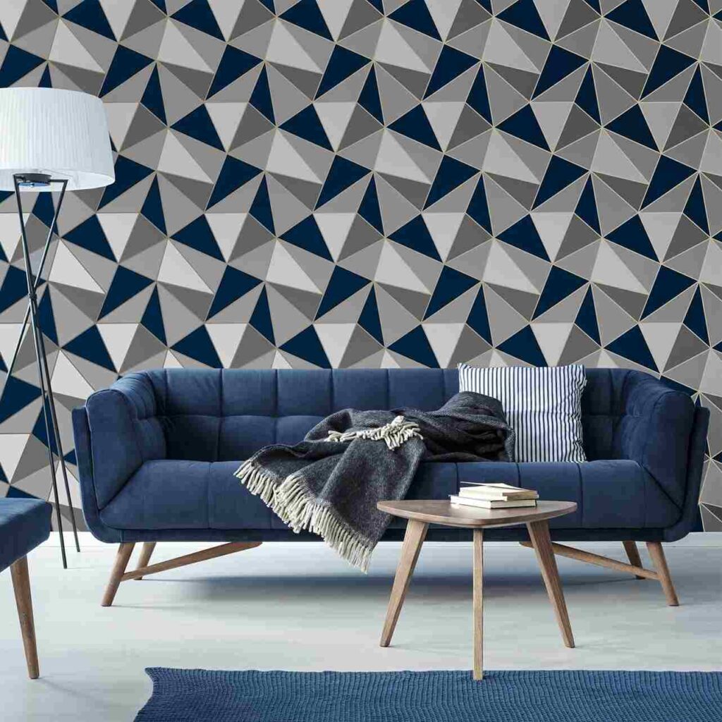 A grey and living room with wallpaper and blue sofa with cushion and throw 