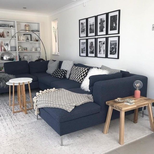 A grey living room with grey cushion and throw and wooden flor and rug on it 