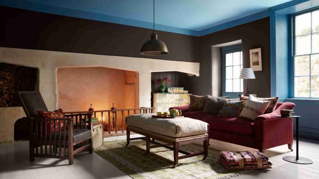 A blue and brown living room with windows and sofa with cushion 