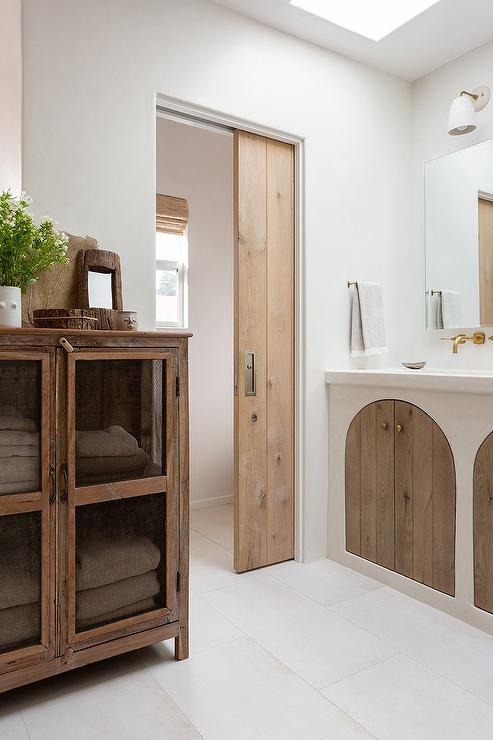 A jack and jill bathroom with sidling door and white floor 
