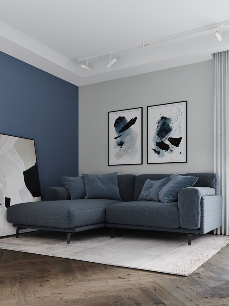 A grey and navy living room with rug on the wooden floor and painting on the wall 