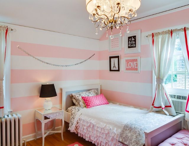 A pink and white bedroom with white vintage table and windows with curtain 