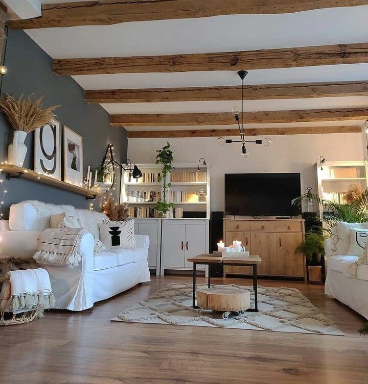 A grey living room with wooden beams and floor and sofa with cushion 