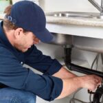plumber-is-doing-plumbing-in-kitchen-sink