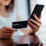 a-girl-is-holding-a-credit-card-and-phone-in-her-hands-and-checking-account-number