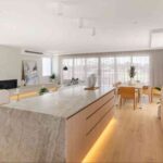 a-large-white-natural-stone-kitchen-island-with-golden-light-underground